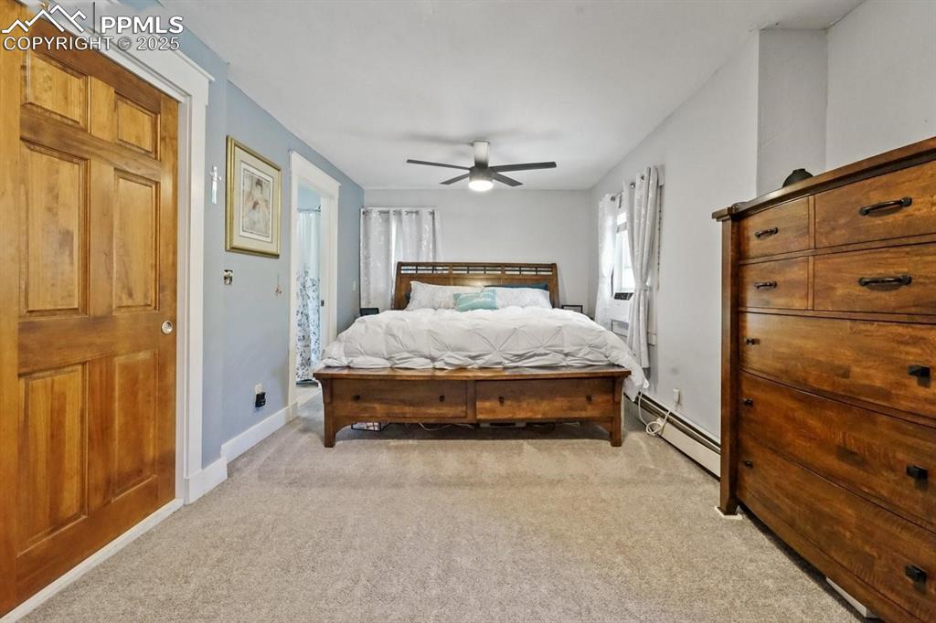 Image 15 of 28: Bedroom featuring light colored carpet, a baseboard radiator, and a ceiling