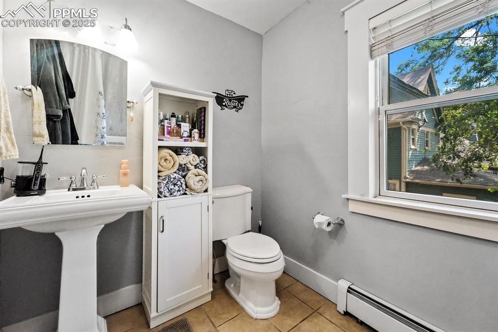 Image 17 of 28: Bathroom featuring baseboard heating and light tile patterned floors