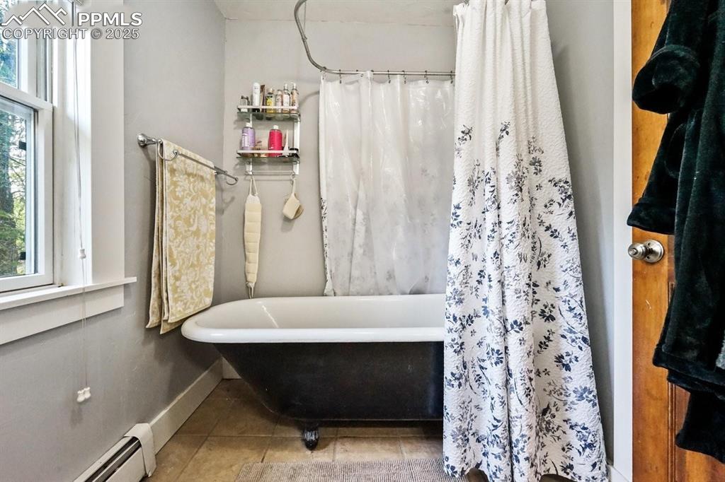 Image 18 of 28: Bathroom featuring a baseboard radiator, tile patterned floors, and a combi