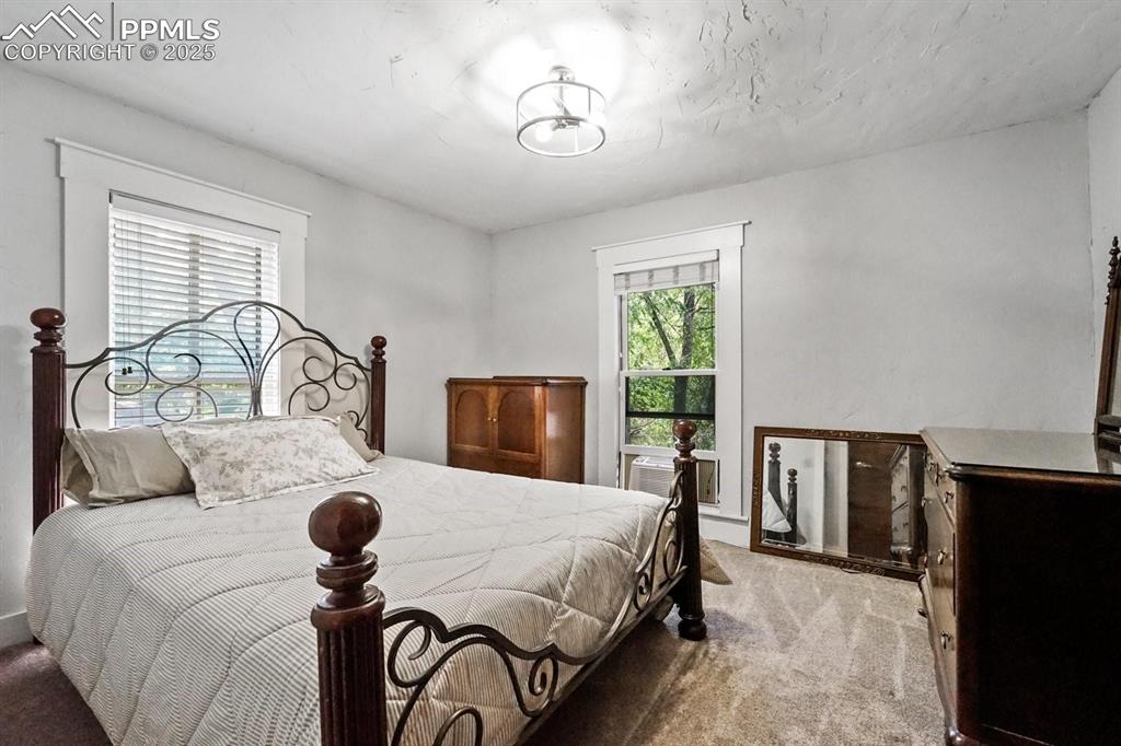 Image 20 of 28: Bedroom featuring light colored carpet and multiple windows