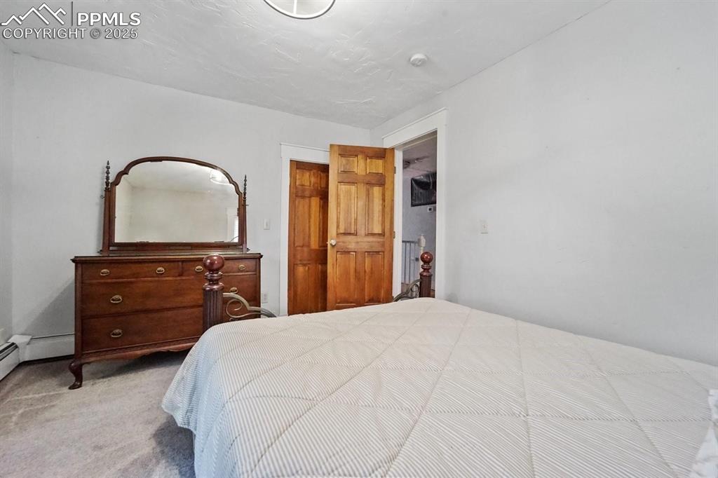Image 21 of 28: Carpeted bedroom with a baseboard heating unit