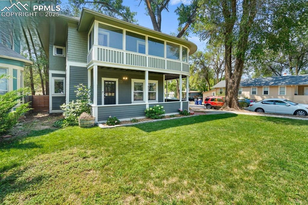 Image 5 of 28: Rear view of property with a yard and a porch