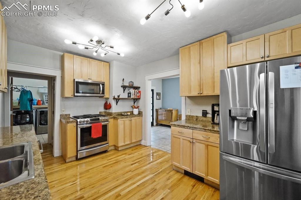 Image 9 of 28: Kitchen with light brown cabinetry, appliances with stainless steel finishe