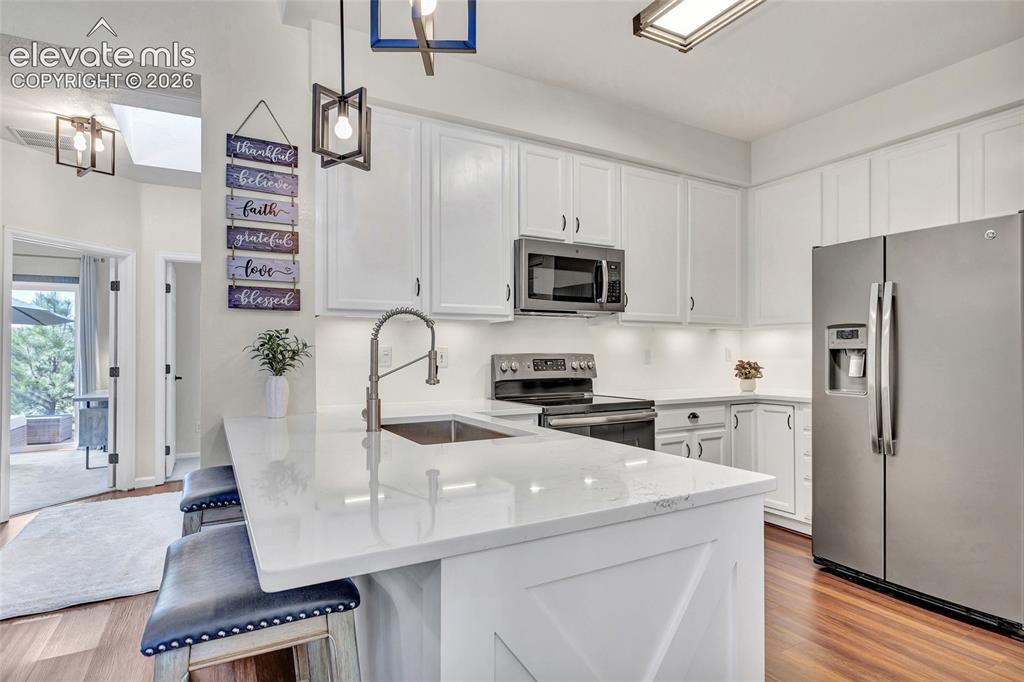 Image 13 of 26: Clean quartz countertops, a professional-style faucet, and stainless applia