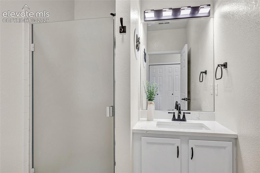 Image 20 of 26: The secondary bathroom features sleek updates and finished with a walk in s