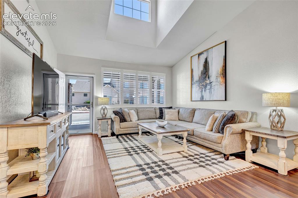 Image 4 of 26: Soaring ceilings, a dramatic windows, and rich hardwood floors set the stag