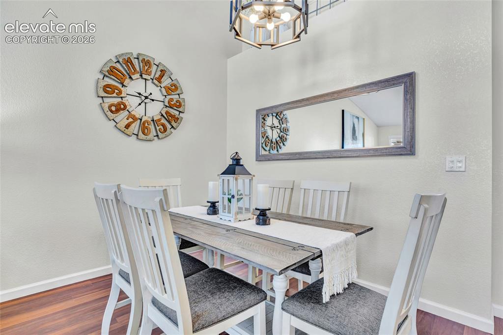 Image 8 of 26: The dining area shines with a rustic farmhouse table, white slatted chairs,