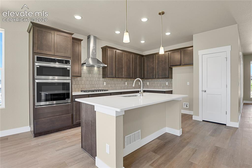 Image 6 of 42: Quartz counters, stainless appliances, and tile backsplash