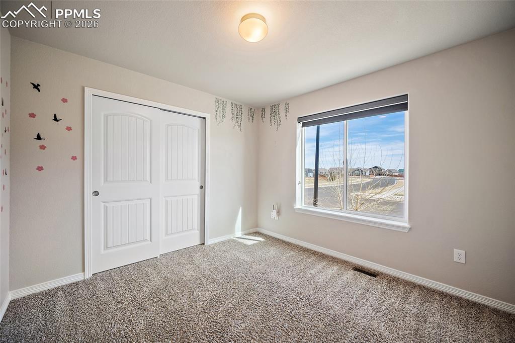 Image 28 of 50: 3rd main level bedroom with carpet and good size closet. 