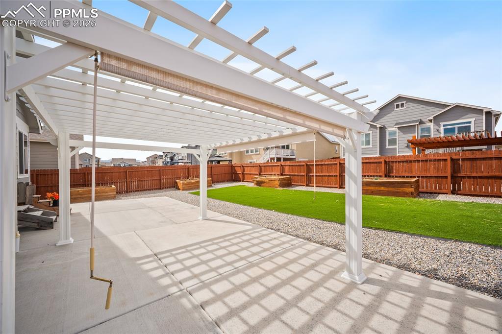 Image 38 of 50: Fully fenced back yard, low maintenance landscaping. Large patio and pergol