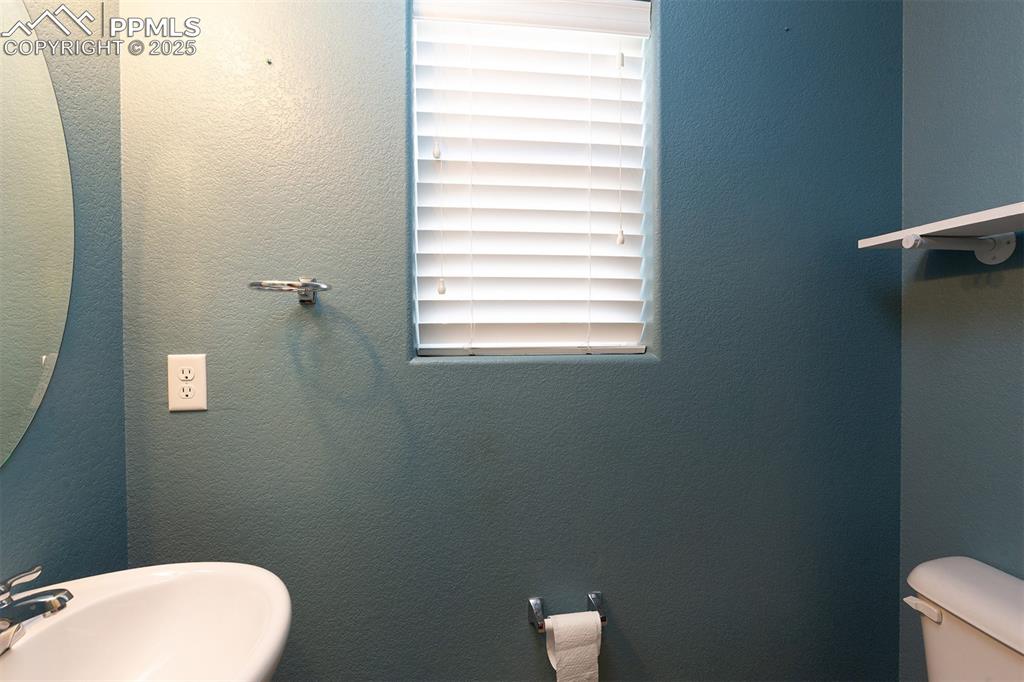 Image 18 of 33: Half bath featuring a textured wall and a sink