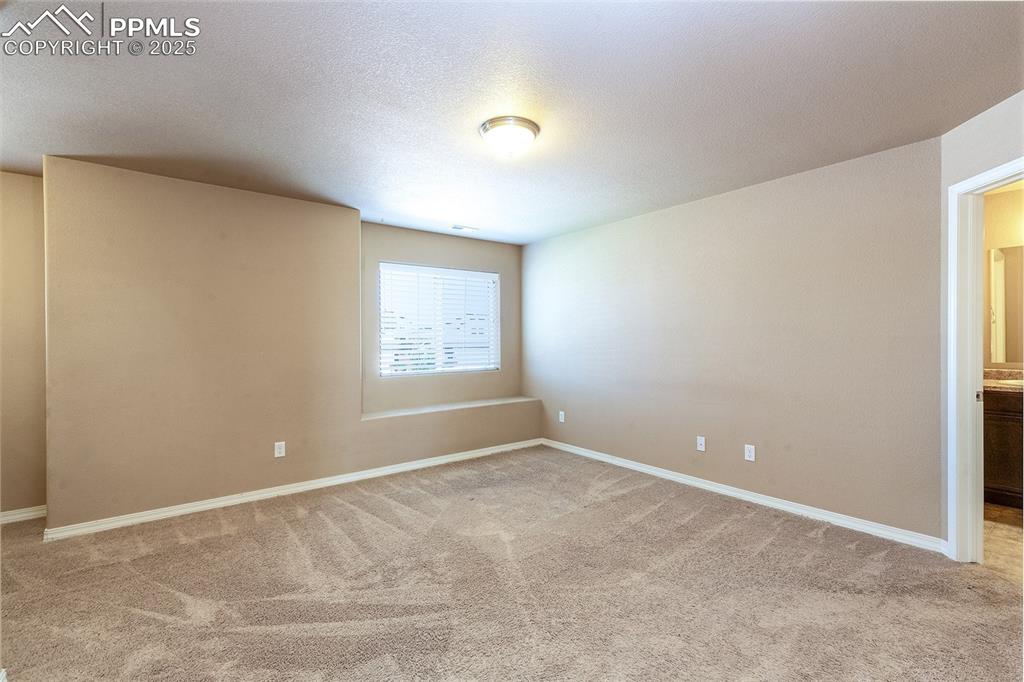 Image 24 of 33: Spare room featuring light carpet and a textured ceiling