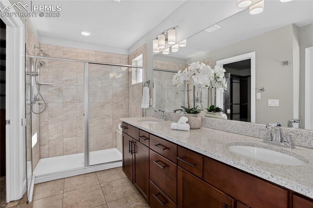 Image 10 of 17: Primary bath w/ dual sink vanity & walk-in shower