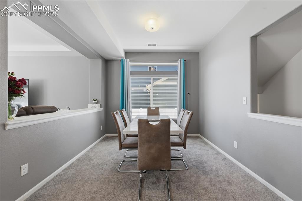 Image 11 of 37: Carpeted dining area featuring baseboards