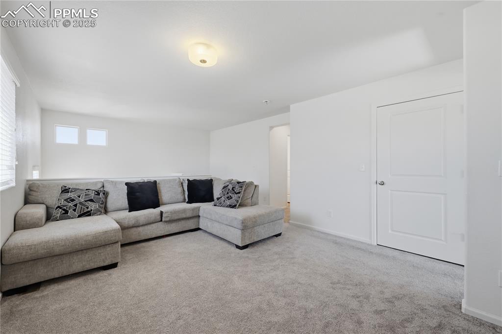 Image 17 of 37: Living area featuring carpet flooring and baseboards