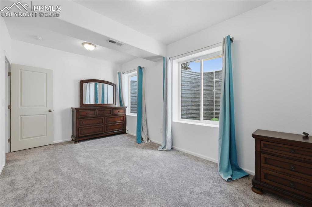 Image 20 of 37: Bedroom with light colored carpet and baseboards