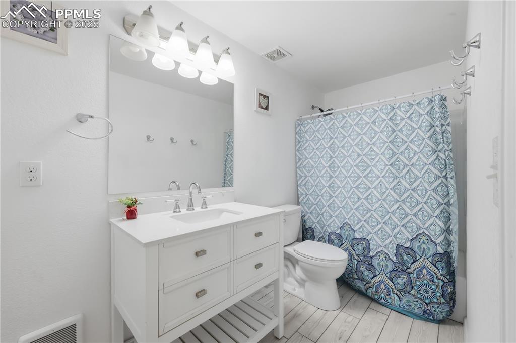 Image 21 of 37: Full bath with vanity, curtained shower, and light wood-style floors