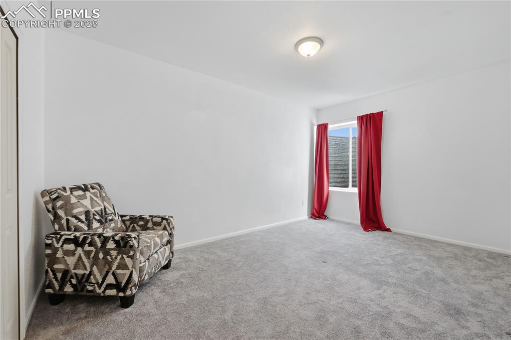 Image 22 of 37: Living area with carpet and baseboards