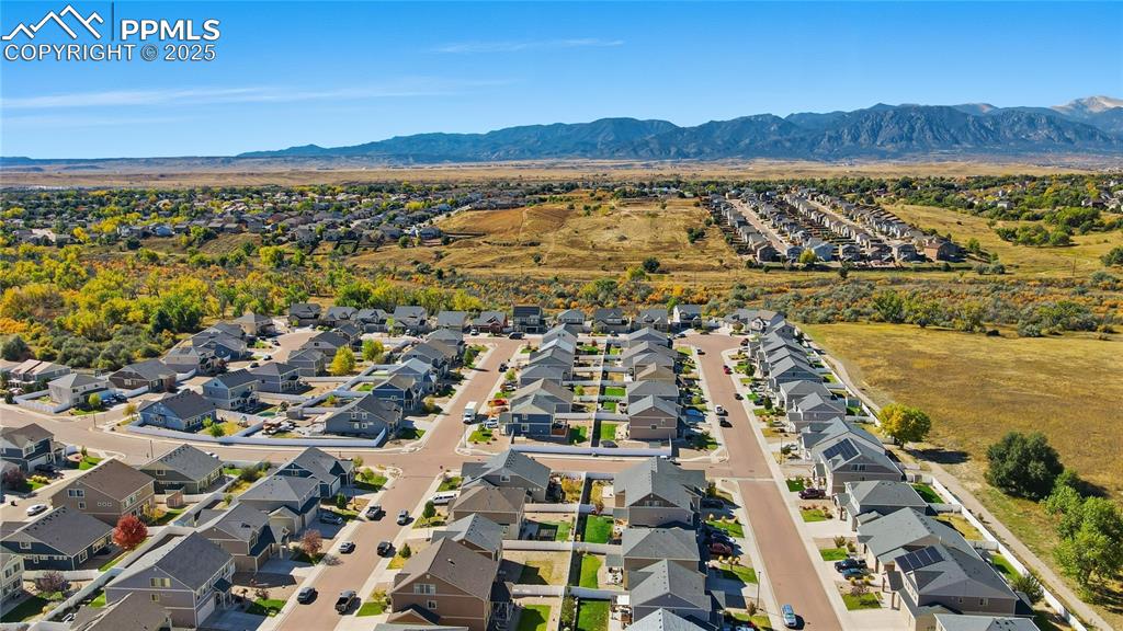 Image 32 of 37: Aerial view of residential area featuring a mountain backdrop