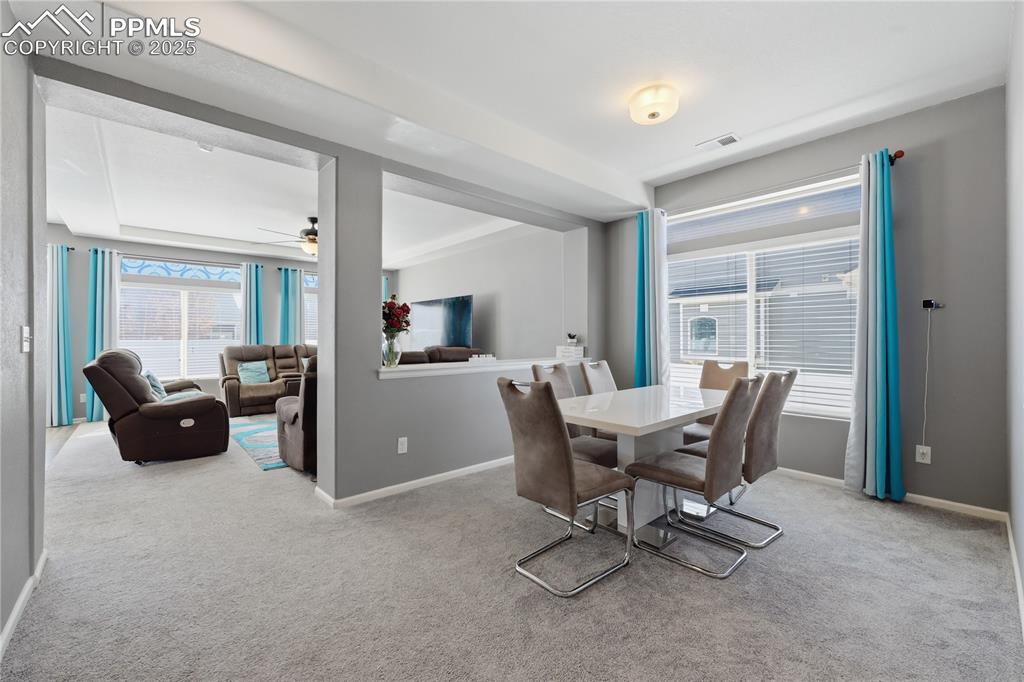 Image 9 of 37: Dining area with light carpet and ceiling fan