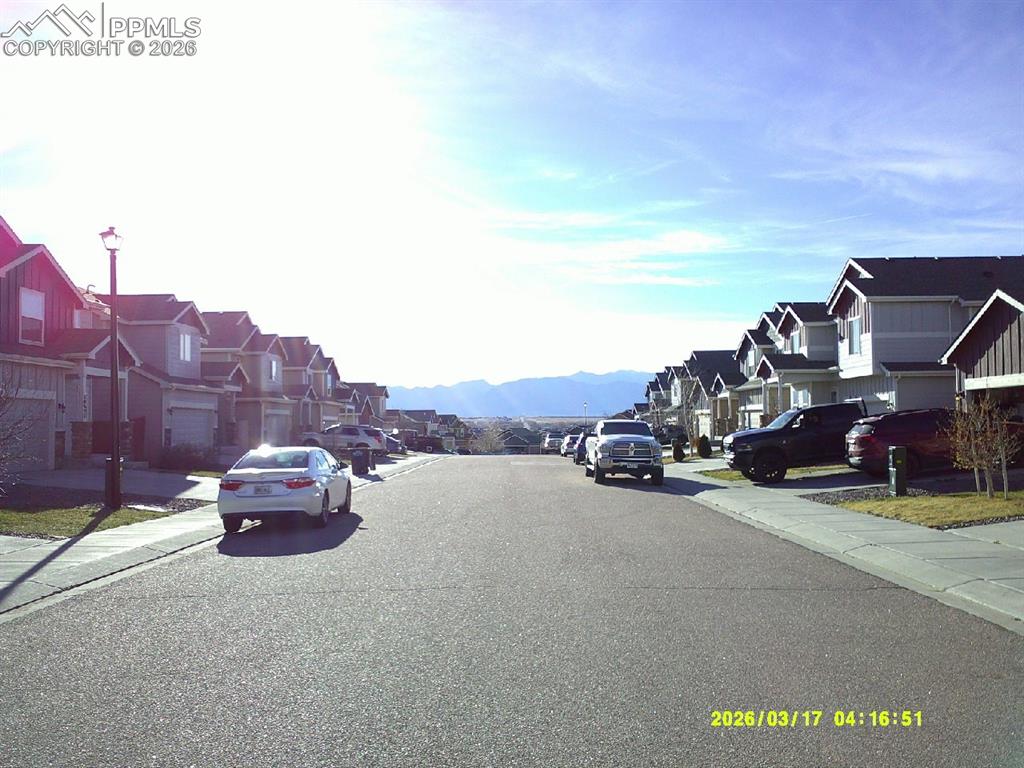 Image 16 of 16: View of asphalt street with sidewalks, a residential view, curbs, and a mou