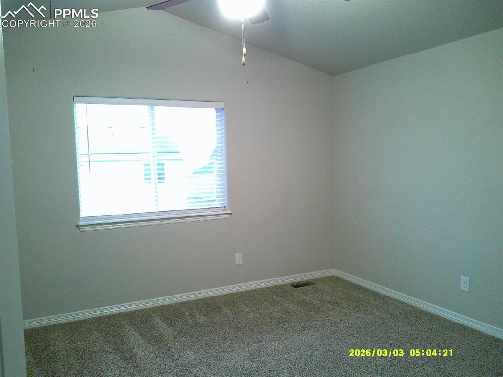Image 4 of 16: Spare room with dark carpet and ceiling fan