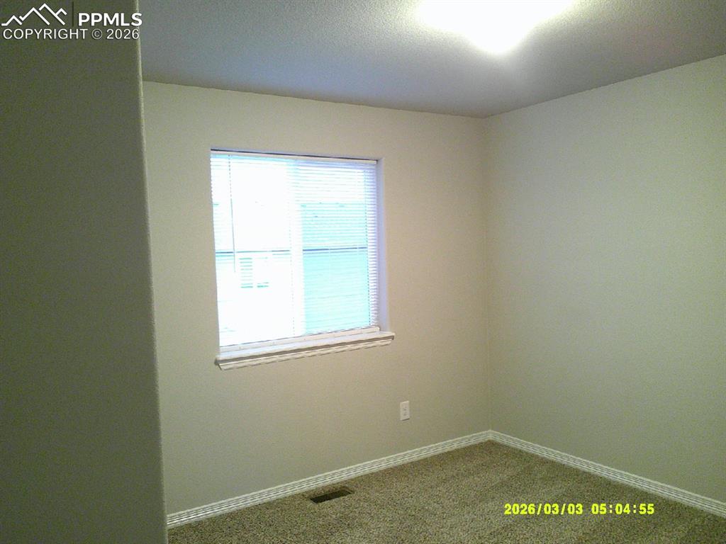 Image 6 of 16: Unfurnished room with carpet and baseboards