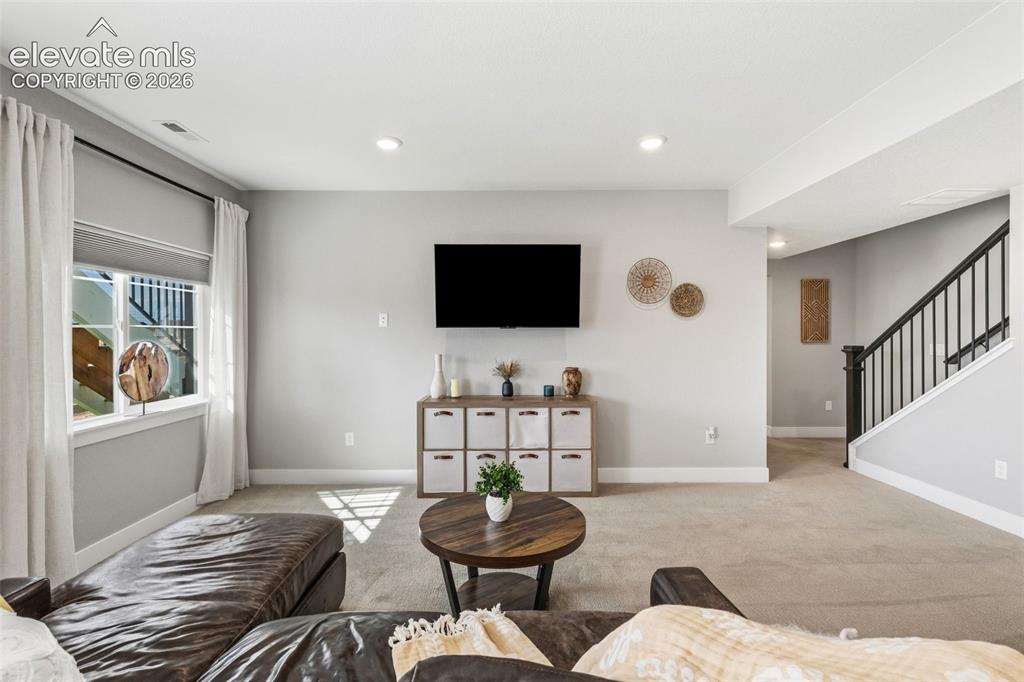 Image 26 of 46: Great Room w/ wet bar on the right side and mechanical room/storage in the