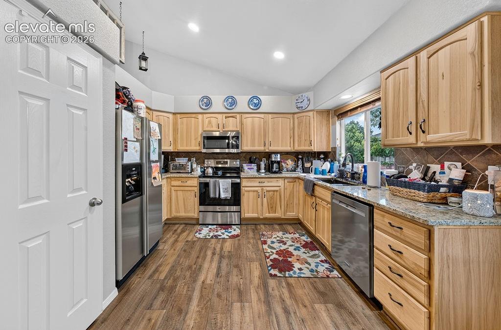 Image 10 of 44: The spacious eat-in kitchen offers abundant storage with hickory cabinets,