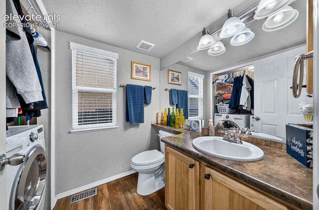 Image 18 of 44: Main level Powder Bathroom and Laundry Area with luxury vinyl wood plank fl