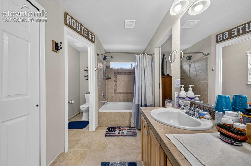 Image 25 of 44: The upper level Primary Bathroom also features a tiled soaking tub and show