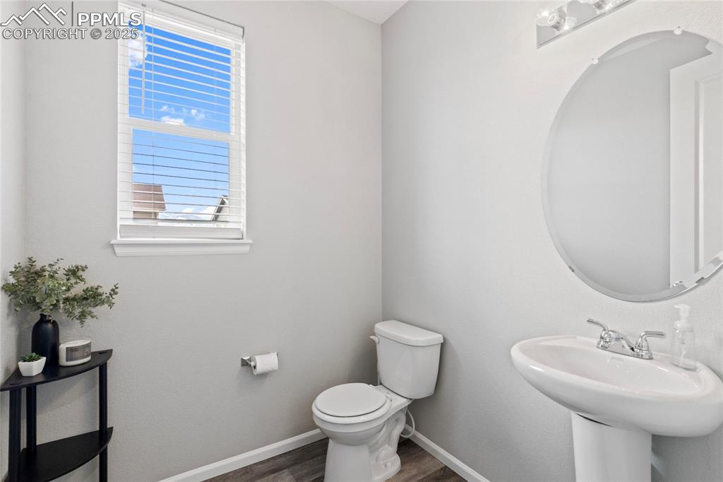 Image 15 of 44: Half bath with baseboards and dark wood-style flooring