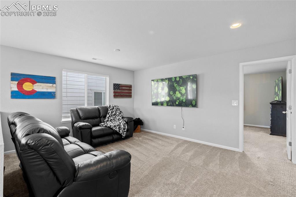 Image 17 of 44: Carpeted living room with baseboards and recessed lighting