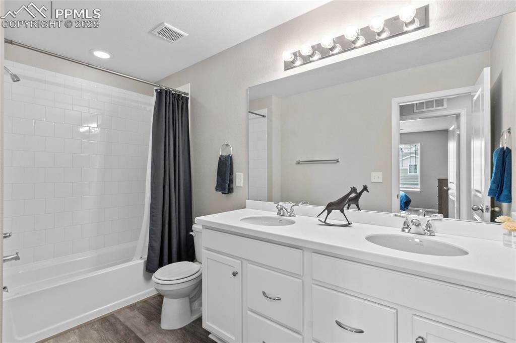 Image 25 of 44: Full bathroom featuring shower / tub combo with curtain, dark wood-type flo