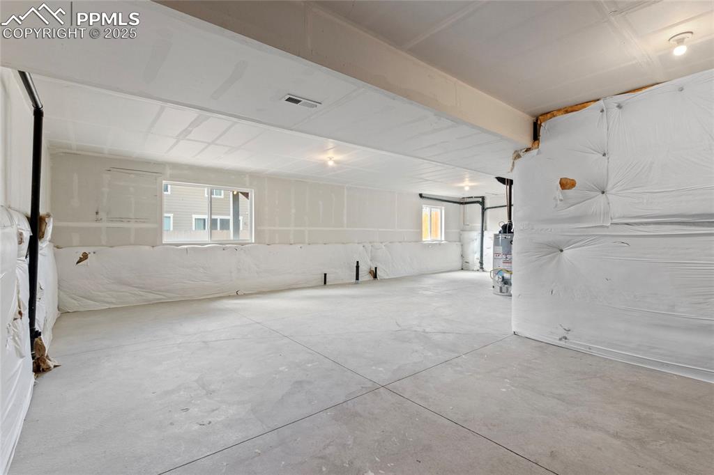 Image 29 of 44: Basement featuring healthy amount of natural light and water heater
