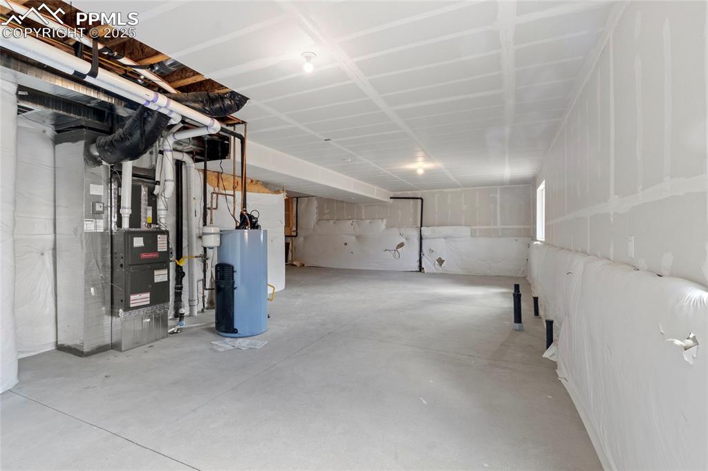 Image 30 of 44: Unfinished basement with water heater and heating unit