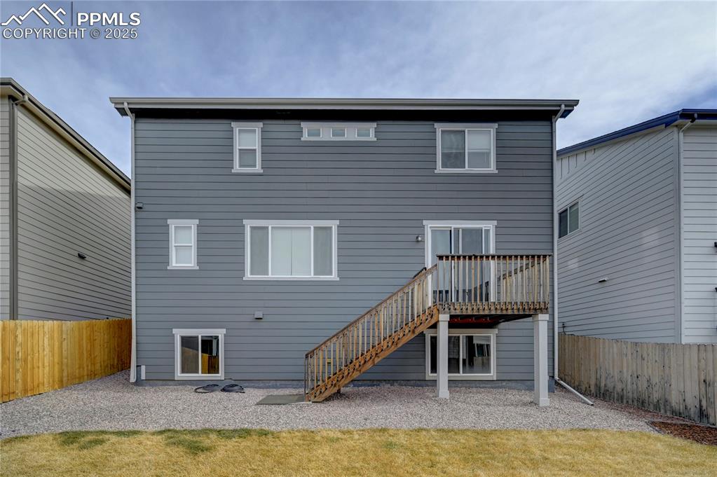 Image 37 of 44: Rear view of house featuring a fenced backyard, stairway, a patio area, and