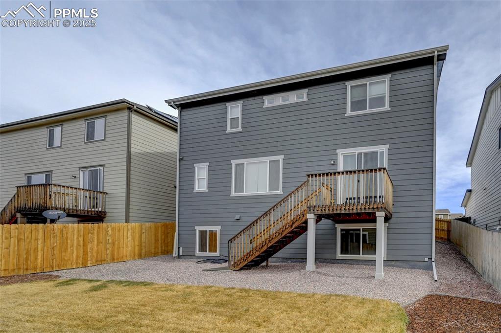 Image 40 of 44: Back of house featuring a fenced backyard and stairway