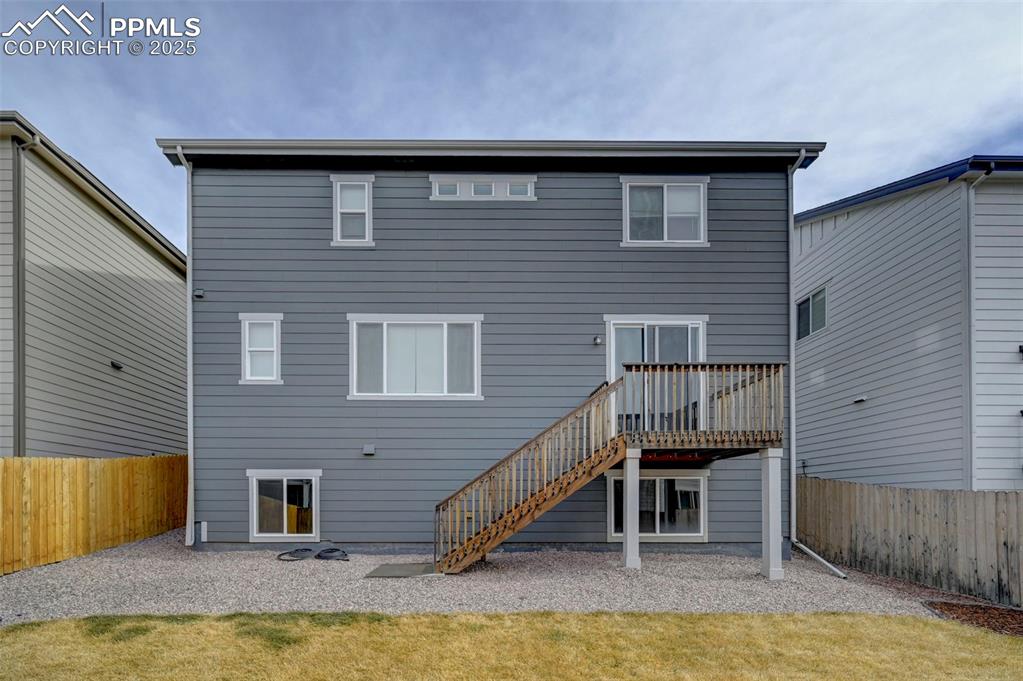 Image 41 of 44: Back of house with a fenced backyard, stairway, a wooden deck, and a patio