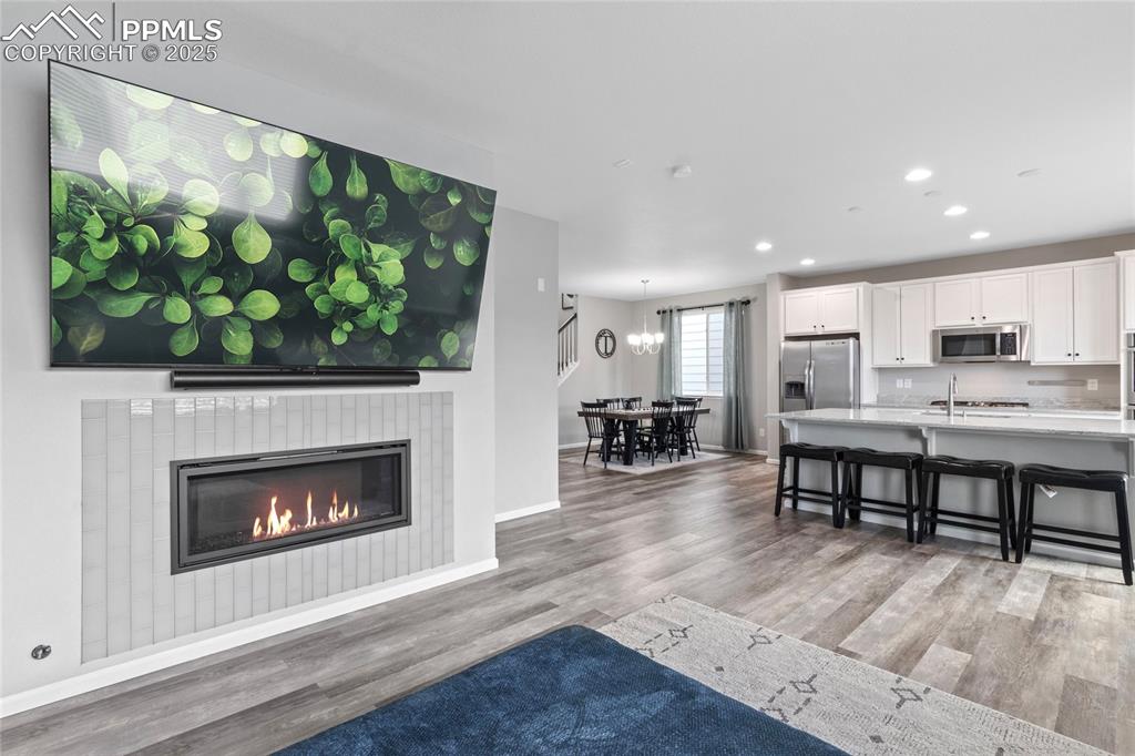 Image 7 of 44: Living room featuring light wood-style floors, recessed lighting, and a til