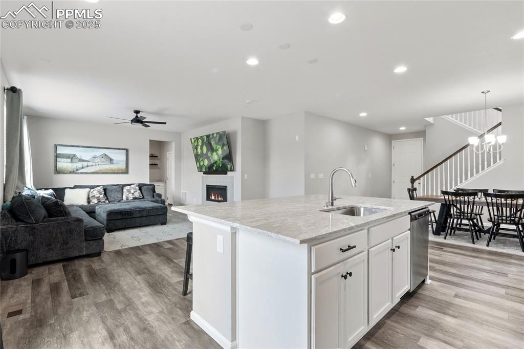Image 9 of 44: Kitchen featuring a kitchen island with sink, recessed lighting, white cabi