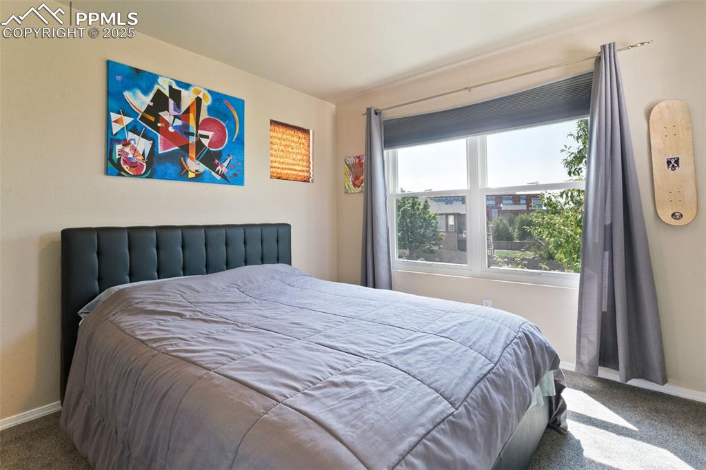 Image 18 of 29: Bedroom with large window, view of Pikes Peak and a walk-in closet