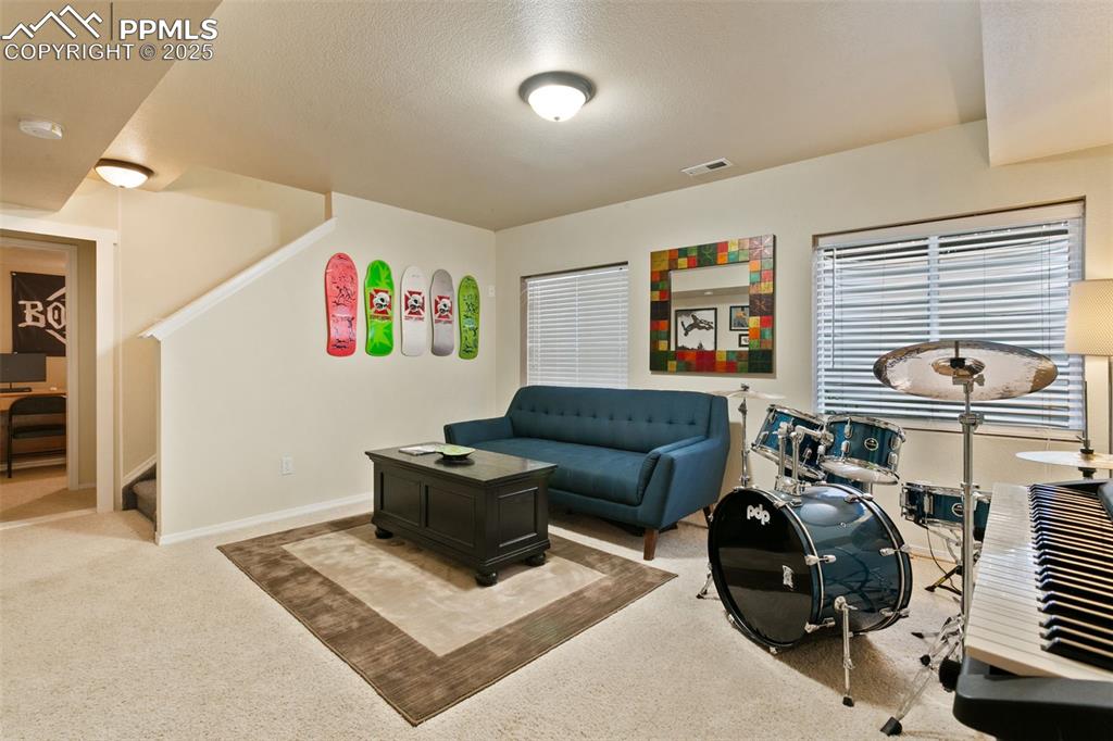 Image 22 of 29: Basement family room with carpet and large windows