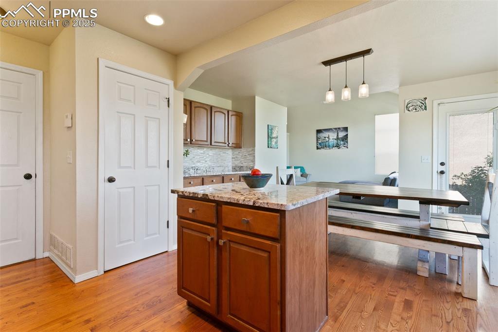 Image 8 of 29: Kitchen island with view of pantry and garage doors