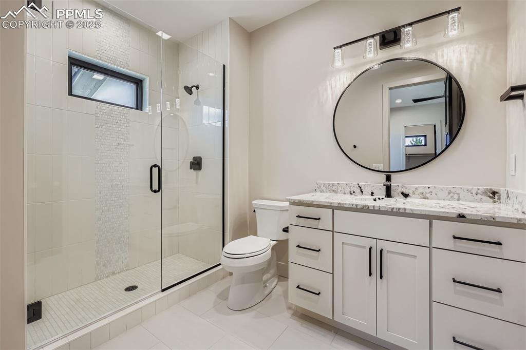 Image 18 of 41: Full bathroom featuring a shower stall, vanity, and light tile patterned fl