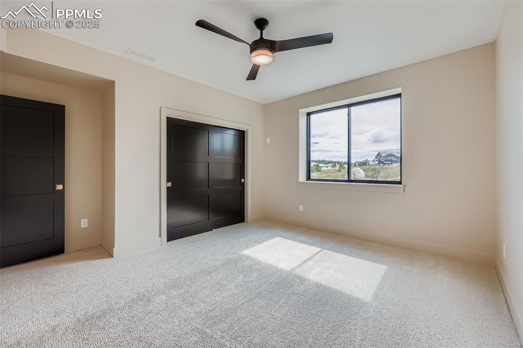 Image 21 of 41: Unfurnished bedroom with carpet flooring, a ceiling fan, and a closet