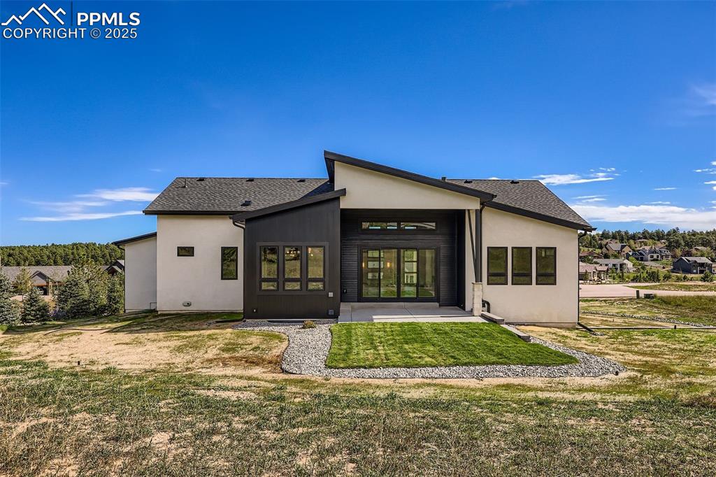 Image 28 of 41: Back of property featuring a patio area, a yard, roof with shingles, and st
