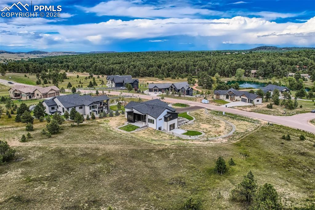 Image 35 of 41: Aerial view of residential area with a heavily wooded area