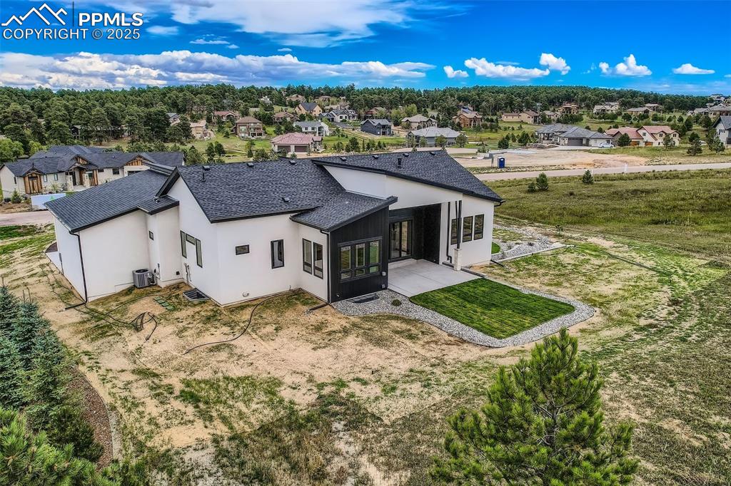 Image 37 of 41: Back of house with a sunroom, stucco siding, a residential view, roof with