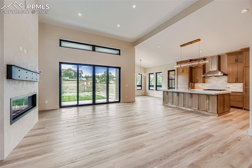 Image 6 of 41: Kitchen featuring open floor plan, tasteful backsplash, a large island, lig